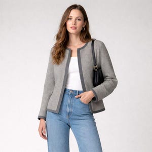 May include: A woman wearing a gray and white houndstooth jacket with gray trim, a white top, and light blue wide-leg jeans. She is also wearing black loafers and carrying a black purse. The outfit is set against a white background.