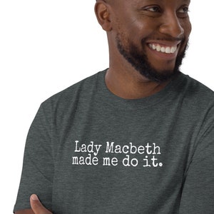 Puede incluir: Una camiseta gris oscuro jaspeada con el texto "Lady Macbeth made me do it." impreso en blanco.