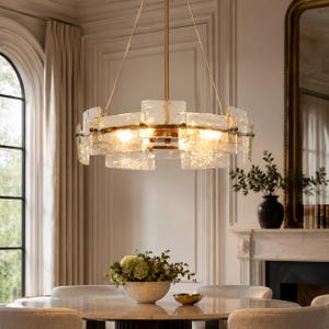May include: A modern chandelier with a gold finish and textured glass panels. The light fixture is suspended from the ceiling and illuminates a dining area. The chandelier's design adds a touch of elegance to the room.