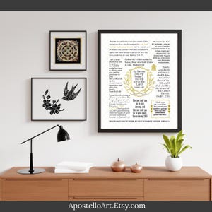 Pode incluir: Três impressões de arte emolduradas em um armário de madeira. As impressões incluem um design floral e de pássaros em preto e branco, um design circular dourado e preto e um versículo bíblico emoldurado com detalhes dourados. Uma luminária de mesa preta e uma pequena planta em vaso também estão presentes.