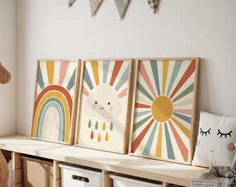 May include: Three framed art prints featuring a rainbow, a smiling cloud with raindrops, and a sunburst design. The prints have a retro color palette of orange, yellow, blue, and green. The art is displayed on a wooden shelf with storage bins.