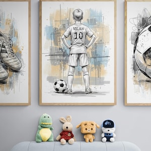 May include: Three framed art prints with a soccer theme. The center print features a soccer player with the name "Milan" and the number "10" on the jersey. A soccer ball is at the player's feet. The bottom of the image shows four stuffed animals.