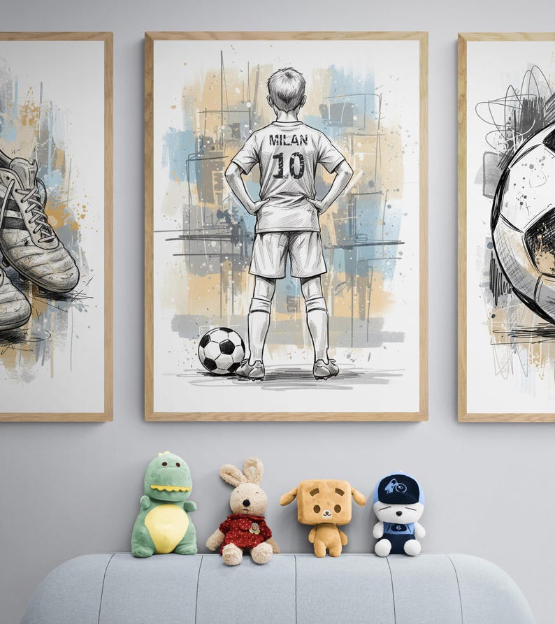May include: Three framed art prints with a soccer theme. The center print features a soccer player with the name "Milan" and the number "10" on the jersey. A soccer ball is at the player's feet. The bottom of the image shows four stuffed animals.