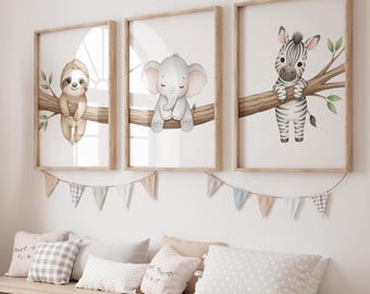 May include: Three framed nursery art prints featuring watercolor illustrations of a sloth, elephant, and zebra on tree branches. The prints are in light wood frames, with a garland of pennants below.