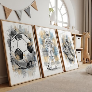 May include: Set of three framed soccer-themed art prints. The prints feature a detailed soccer ball, a soccer player in a jersey, and a pair of soccer cleats. The artwork is in black, white, and shades of blue and tan.