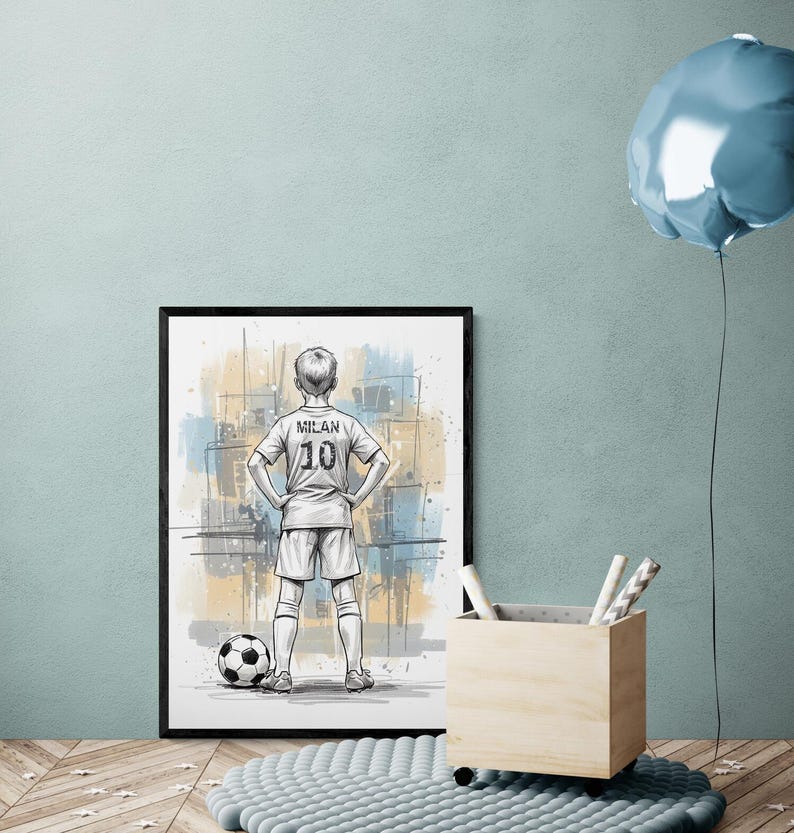May include: Framed artwork featuring a soccer player in a white jersey with "MILAN 10" on the back, standing with hands on hips next to a soccer ball. The background has abstract blue and yellow paint strokes. A soccer-themed art print.