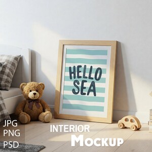 Könnte beinhalten: Ein gerahmter Druck mit einem hellblauen und weißen gestreiften Hintergrund und dem Text "Hello Sea" in dunkelblau. Der Druck ist in einem hellen Holzrahmen und liegt auf einem Holzboden.