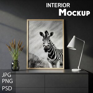 Könnte beinhalten: Ein gerahmtes Foto-Mockup mit einem Schwarz-Weiß-Zebra-Druck auf einer dunkelgrauen Kommode mit einer weißen Lampe und einer Vase mit getrockneten Blumen.