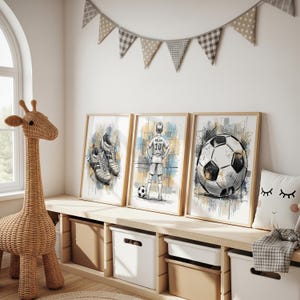 May include: Three framed soccer-themed art prints. The prints feature illustrations of soccer cleats, a soccer player, and a soccer ball. The artwork is in neutral tones with a watercolor effect. The prints are displayed on a wooden shelf with storage bins.