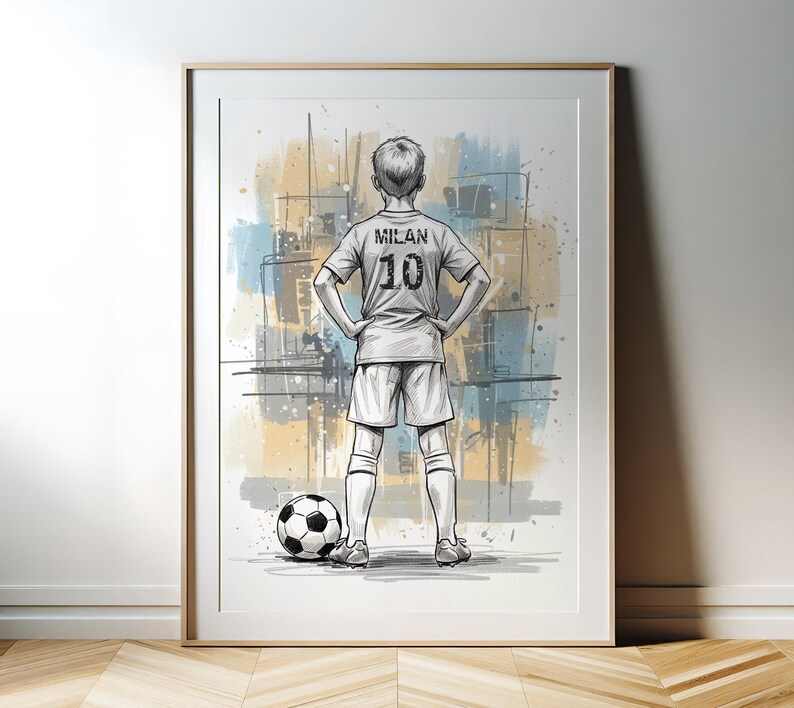 May include: Framed artwork of a soccer player in a jersey with "MILAN" and the number "10" on the back. The player stands with hands on hips next to a soccer ball. The background features abstract blue and yellow paint strokes.