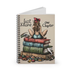 Puede incluir: Una libreta de espiral con una ilustración colorida de una mujer sentada en una pila de libros. La mujer tiene el pelo largo y rojo y lleva una falda vaquera azul. El texto "Just More" y "One Chapter" está impreso en la portada.