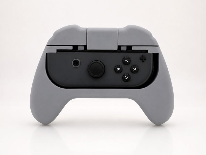 Op de afbeelding: Een grijze controller grip voor een gameconsole. De grip is ontworpen om een zwarte controller met de knoppen A, B, X en Y vast te houden. De grip heeft een gebogen ontwerp voor comfortabele bediening.