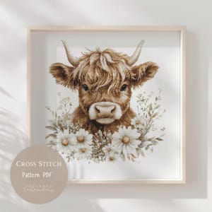 May include: A framed cross-stitch pattern featuring a Highland cow with a brown coat and horns, surrounded by white daisies and greenery. The text "Cross Stitch Pattern PDF" is displayed on a circular graphic.
