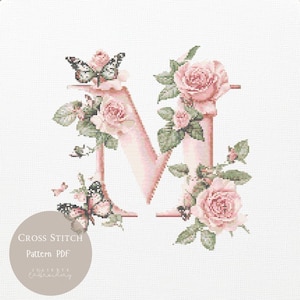 May include: A cross stitch pattern of the letter "N", in pale pink, decorated with pink roses, green leaves, and butterflies. The design includes the text "Cross Stitch Pattern PDF" in a circular graphic.