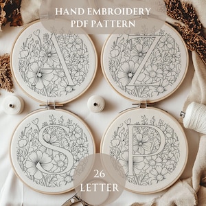 Può includere: Quattro telai da ricamo con disegni floreali e le lettere A, Z, S e P. Il testo "HAND EMBROIDERY PDF PATTERN" è in alto. Il testo "26 LETTER" è in basso. I disegni sono in bianco e nero.