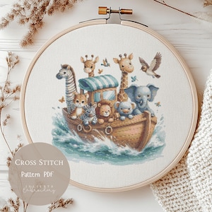 May include: A cross-stitch pattern featuring a boat filled with cartoon animals, including giraffes, an elephant, and a zebra. The design is set in a wooden embroidery hoop. The text "Cross Stitch Pattern PDF" is visible.