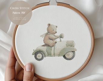 Pode incluir: Padrão de ponto cruz com um urso de pelúcia andando de scooter vintage. O urso é marrom claro com um lenço verde, e a scooter é verde claro com listras. O texto "Cross Stitch Pattern PDF" está no canto superior esquerdo.
