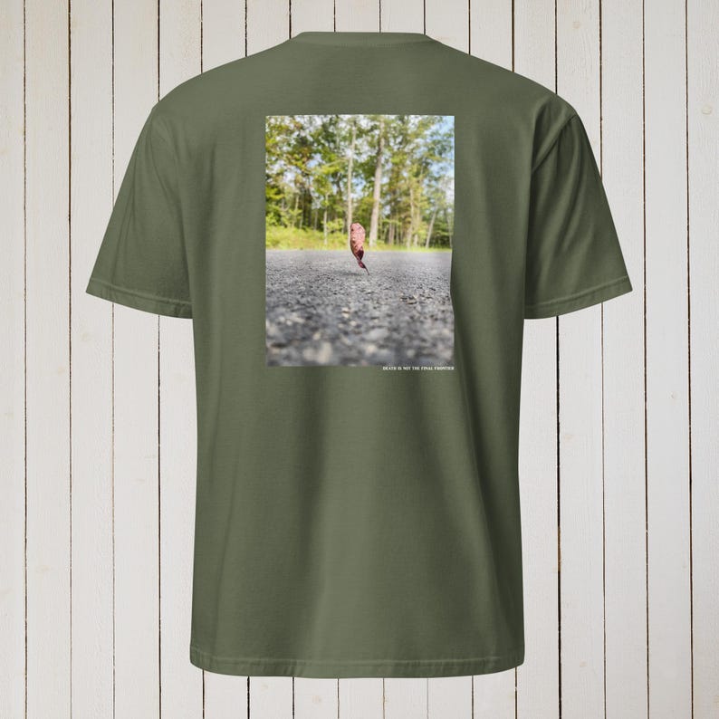 Peut inclure: Un t-shirt vert avec une photo d'une seule feuille sur une route pav&eacute;e. Le texte "Death is not the final frontier" est imprim&eacute; sous la photo.