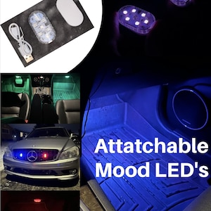 May include: Attachable Mood LED's.  A set of two oval-shaped LED lights with a USB charging cable. The lights are shown installed in a car, illuminating the interior with blue and red light.