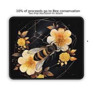 May include: A black mousepad with a gold geometric design featuring a bee and yellow flowers. The text "10% of proceeds go to Bee conservation" is at the top of the mousepad.