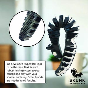 May include: A black and white toy with a flexible, segmented design, featuring a close-up of the linked segments in a circular inset. The text reads "We developed HyperFlexi links..." and the Skunk Prints logo is visible.