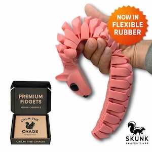 Pink flexible 3D printed squirrel fidget toy for sensory seekers, ADHD, and autism, shown bending in a hand with premium gift box packaging by Skunk Prints