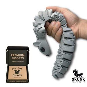 Sensory Squirrel fidget toy in playful motion, tail flipping upward when the hips are squeezed. The articulated diamond-pattern body flexes smoothly and creates a gentle ASMR clack sound. Designed as a unique stress-relief desk toy for adults, this full-size squirrel toy offers tactile sensory feedback and endless entertainment at work or home