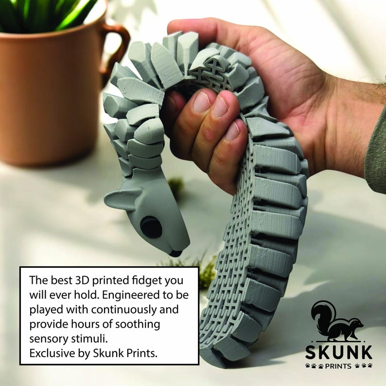 May include: A gray 3D-printed fidget toy shaped like a squirrel, held in a hand. The toy is segmented and flexible. Text on the image reads: "The best 3D printed fidget you will ever hold. Engineered to be played with continuously and provide hours of soothing sensory stimuli. Exclusive by Skunk Prints."