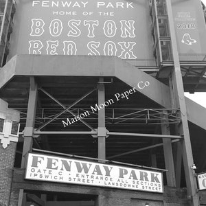 May include: A black and white photo of Fenway Park, home of the Boston Red Sox. The sign above the entrance reads "Fenway Park, Home of the Boston Red Sox".  The sign also includes the text "Maison Moon Paper Co" and "World Series Champions 2018".