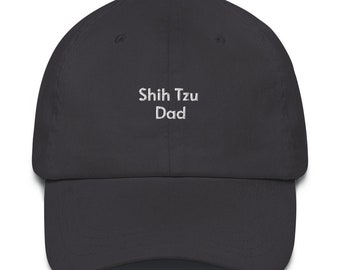 May include: A dark gray baseball cap with the embroidered text "Shih Tzu Dad" in white. The cap has a curved brim and a fabric strap closure on the back. This hat is a great gift for Shih Tzu dog lovers.