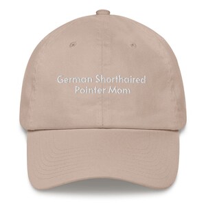May include: A beige baseball cap with the text "German Shorthaired Pointer Mom" embroidered in white on the front.