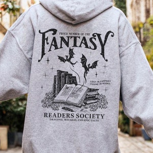 May include: A gray hooded sweatshirt with a black graphic print on the back. The graphic features a stack of books, two bats, and the text "Proud Member of the Fantasy Readers Society, Dragons, Wizards and Epic Tales".