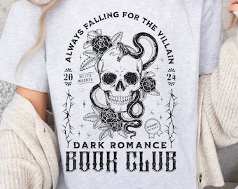 May include: A gray t-shirt with a black and white graphic design. The graphic features a skull with a snake wrapped around it, roses, and the text "Always Falling for the Villain 20 Meets Weekly 24" and "Dark Romance Book Club".