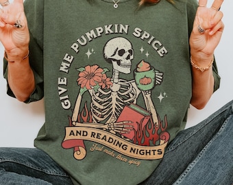 May include: A green t-shirt with a skeleton holding a book and a cup of pumpkin spice. The text on the shirt reads "Give me pumpkin spice and reading nights. Just make them spicy."