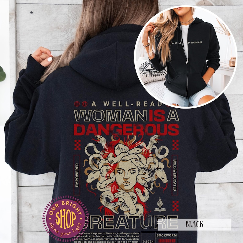 Op de afbeelding: Zwarte hoodie met ritssluiting met de tekst "A Well-Read Woman Is A Dangerous Creature" en een Medusa-afbeelding. Het ontwerp bevat de woorden "Empowered" en "Bold & Educated". Een kleinere afbeelding toont een vrouw die een vergelijkbare hoodie draagt.