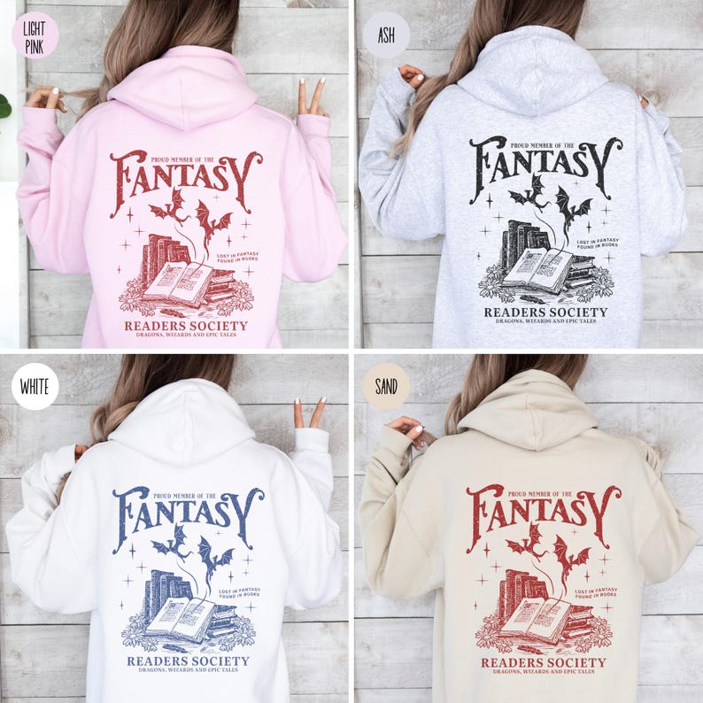 May include: Four different color hooded sweatshirts with a graphic print on the back. The graphic features a stack of books with a dragon flying above them. The text reads "Proud Member of the Fantasy Readers Society Dragons, Wizards and Epic Tales". The colors of the sweatshirts are light pink, ash, white, and sand.