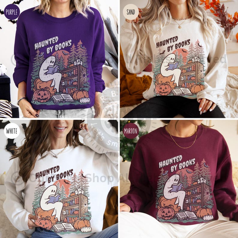 May include: Crewneck sweatshirts in purple, sand, white, and maroon feature a Halloween-themed graphic. The design includes a ghost reading a book, pumpkins, and the text "HAUNTED BY BOOKS". The sweatshirts are a cozy fall fashion item.
