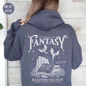 May include: Dark heather grey hoodie with a white graphic print of a stack of books, dragons, and the text "Proud Member of the Fantasy Readers Society. Dragons, Wizards and Epic Tales. Lost in Fantasy Found in Books."