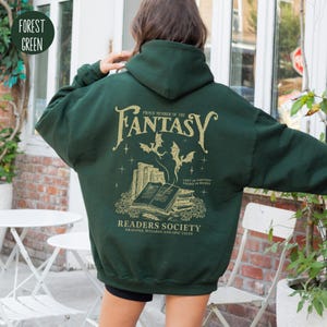 May include: Forest green hooded sweatshirt with a gold graphic print of a stack of books, dragons, and the text "Proud Member of the Fantasy Readers Society. Dragons, Wizards and Epic Tales."