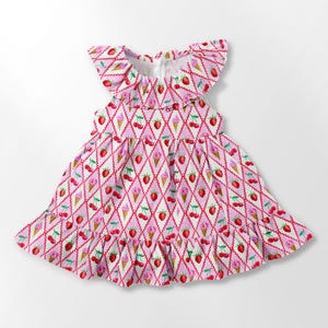 K&ouml;nnte beinhalten: Ein rosa-wei&szlig; gemustertes Kleid mit Erdbeeren, Kirschen und Eiswaffeln. Das Kleid hat einen ger&uuml;schten Ausschnitt und Saum sowie einen Rei&szlig;verschluss hinten. Das Kleid ist f&uuml;r ein Kind konzipiert.