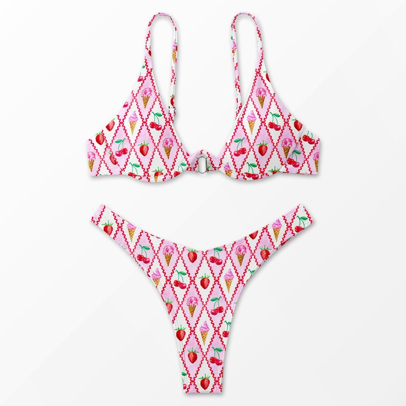 K&ouml;nnte beinhalten: Zweiteiliger Bikini mit einem sich wiederholenden Muster aus Eiswaffeln, Kirschen und Erdbeeren auf einem rosa-wei&szlig;en Rautenmuster. Das Oberteil hat verstellbare Tr&auml;ger und einen Verschluss. Der Unterteil ist im String-Stil.
