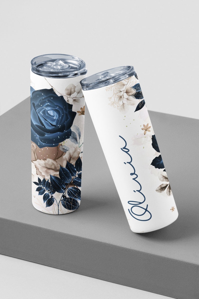 Tilted view of custom tumblers, Olivia name in cursive, stylish floral and leaf design for gifts.