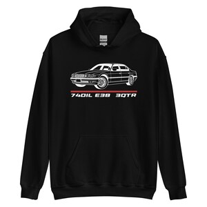 May include: Black hooded sweatshirt featuring a white car graphic and the text "740iL E38 30TR". The car is a detailed line drawing of a sedan. The text is in a sans-serif font and is positioned below the car graphic.