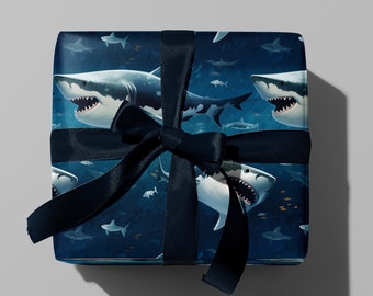 May include: A blue gift box with a black ribbon. The box is wrapped in wrapping paper with a pattern of white sharks swimming in a blue ocean.