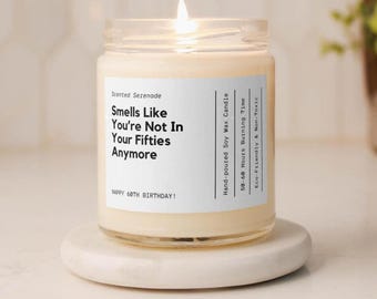 May include: A clear glass jar candle with a white label featuring black text that reads: Scented Serenade, Smells Like You're Not In Your Fifties Anymore, Happy 60th Birthday, Hand-poured Soy Wax Candle, 50-60 Hours Burning Time, Eco-Friendly & Non-Toxic.