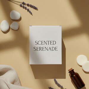 a white box with the text "SENTED SERENADE" on it, surrounded by various items such as a bottle, stones, and lavender.