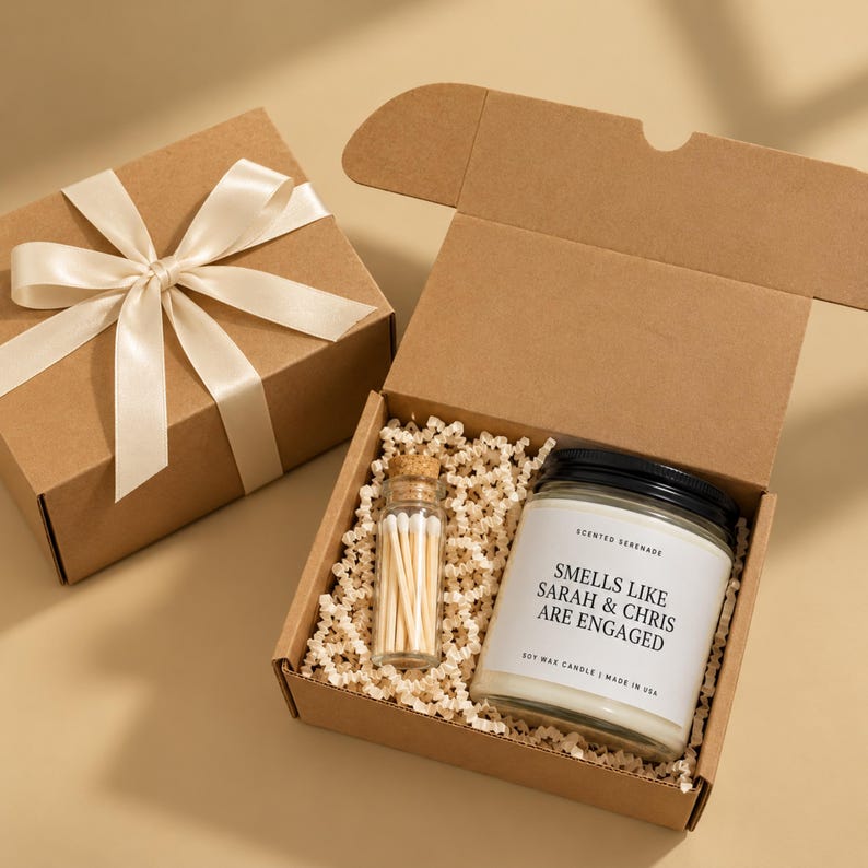 a gift box containing a candle and a set of matchsticks, placed on a beige background.