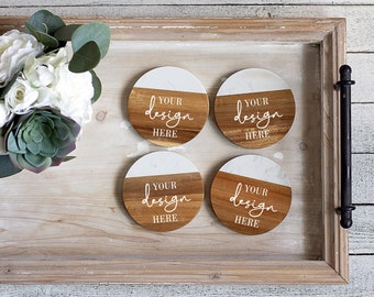 Puede incluir: Cuatro posavasos redondos de madera con parte superior de mármol blanco. Cada posavasos tiene el texto "YOUR design HERE" escrito en la madera.