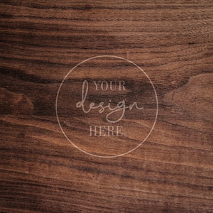 May include: A close-up of a dark brown woodgrain background with a white circle that says "YOUR design HERE" in a handwritten font.