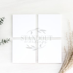 May include: Four blank white square cards arranged in a 2x2 grid on a white wood background. A sprig of green eucalyptus is on the left and a bunch of dried beige grass is on the right. The text "STANDOUT mockups" is in the center of the image.